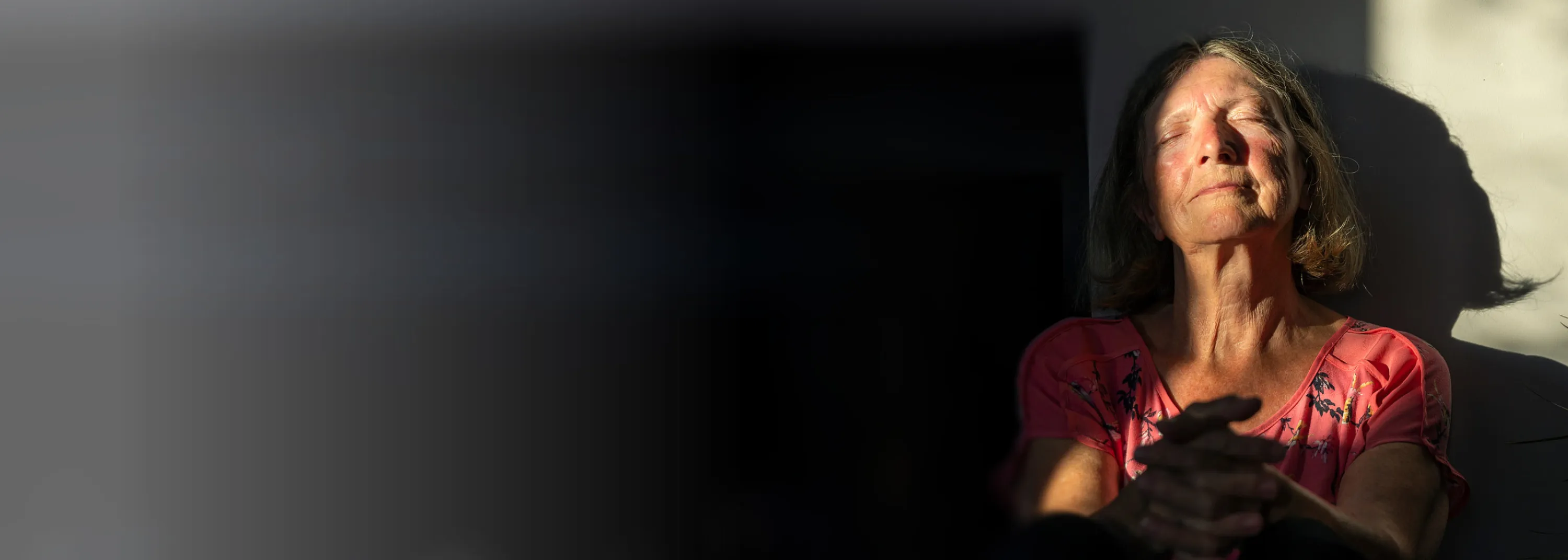 Eine ältere Dame mit Brille arbeitet an ihrem Tablet